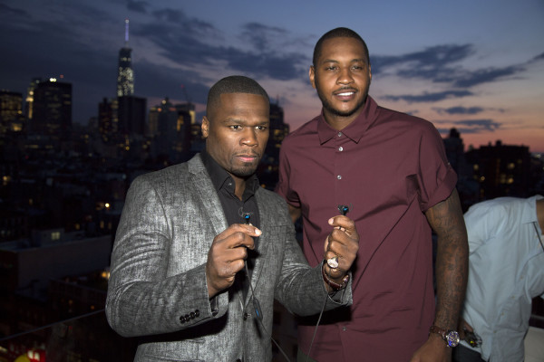 SMS Audio CEO Curtis '50 Cent' Jackson shows off a pair of the new SMS Audio BioSport In-Ear Headphones powered by Intel alongside NY Knicks basketball star Carmelo Anthony