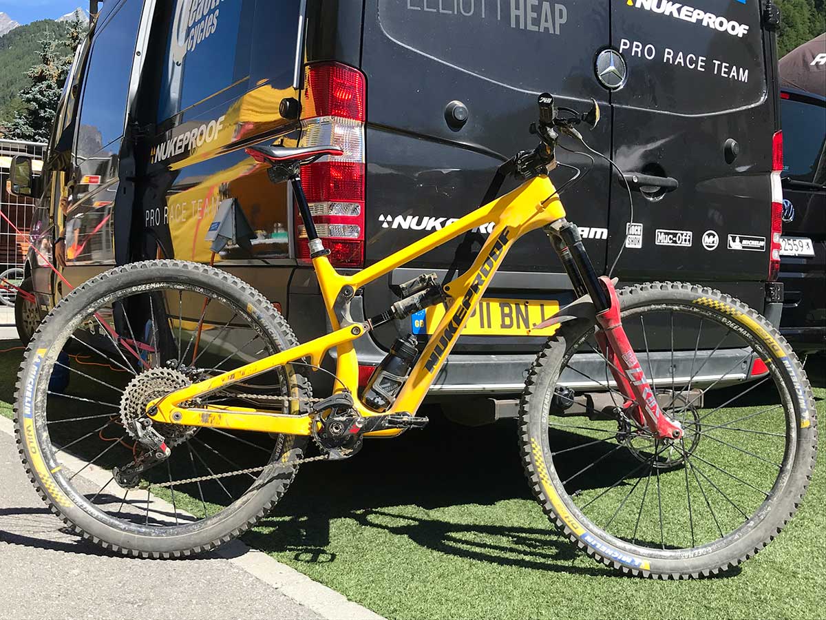 possible 2021 nukeproof mega enduro bike prototype leaning against team crc race van pit area ews zermatt 2020