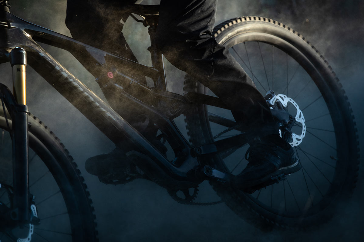 close up shot specialized stumpjumper evo being ridden through a dusty corner at speed low lighting
