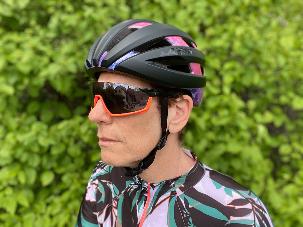 female cyclist showing how a bicycle helmet should fit properly and how the straps should be positioned on the side and under the chin