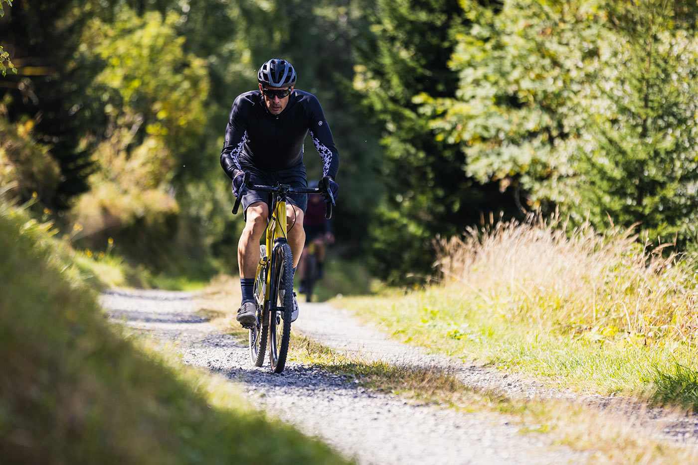 riding the bmc urs lt full suspension gravel bike on a gravel road