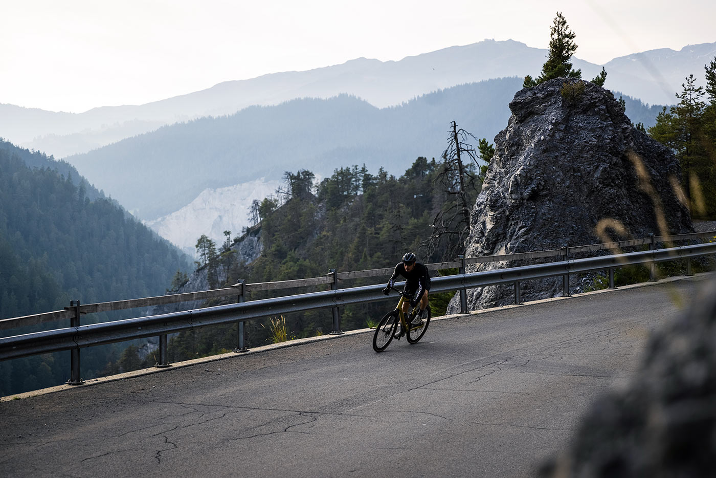 riding the bmc urs lt full suspension gravel bike on a paved mountain pass in switzerland