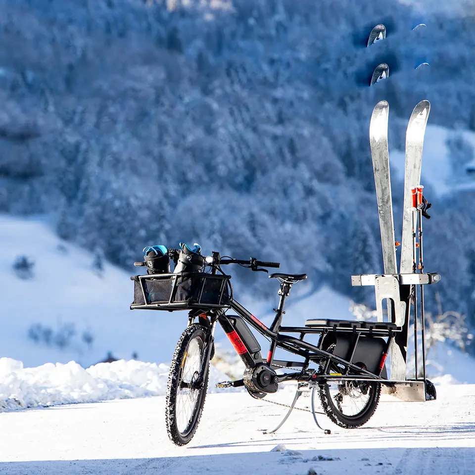 Yuba Spicy Curry AT cargo bike loaded with skis. Angled front view.