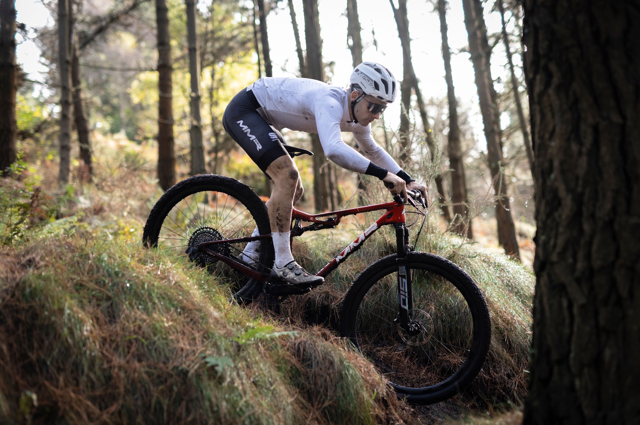 Rider on a Kenta SL in red going downhill. Side view.