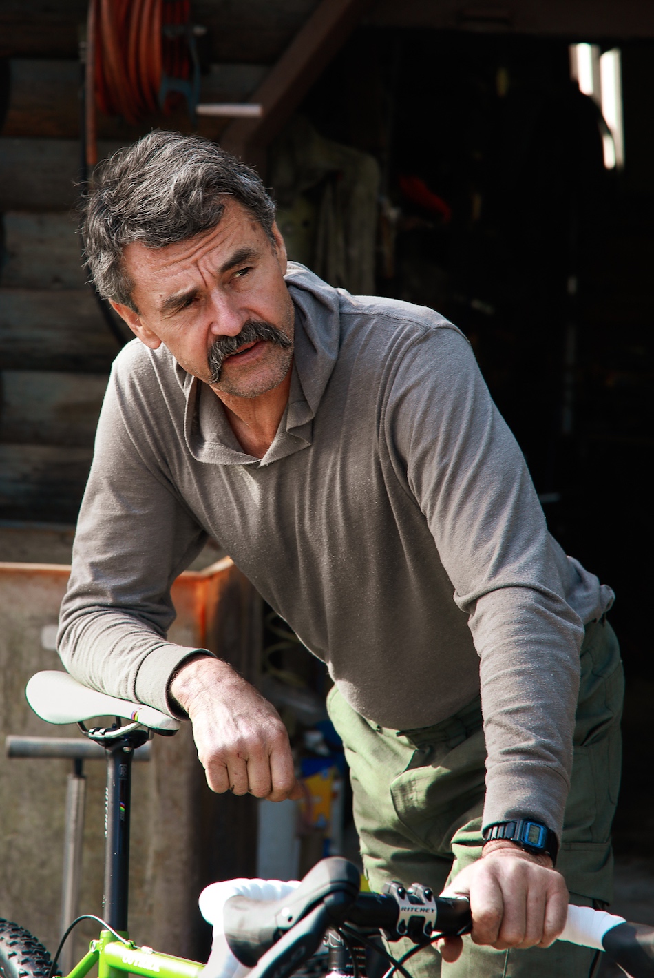 Portrait of Tom Ritchie leaning on a bicycle.