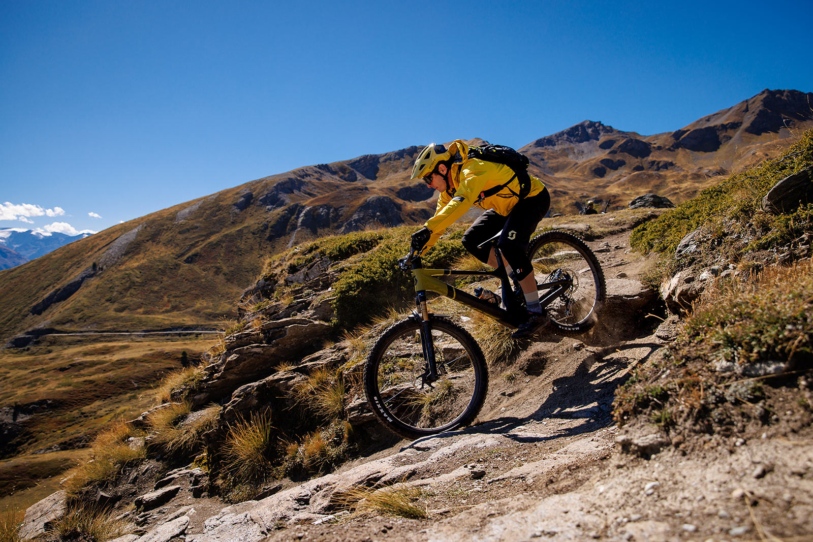 rider dropping off rock ledge on new scott genius mountain bike