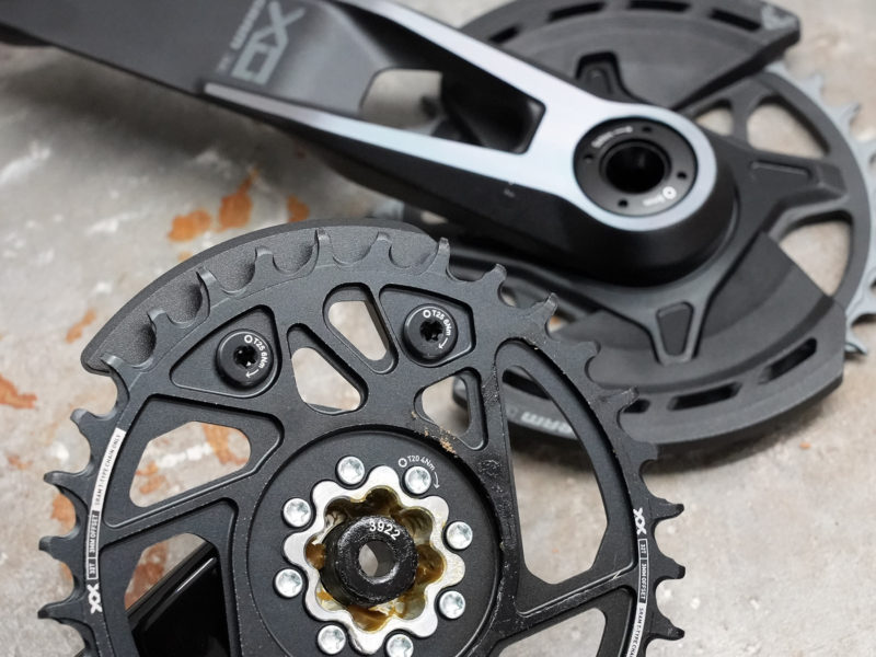closeup of XX and XO chainring and integrated bash guards on T-Type cranksets