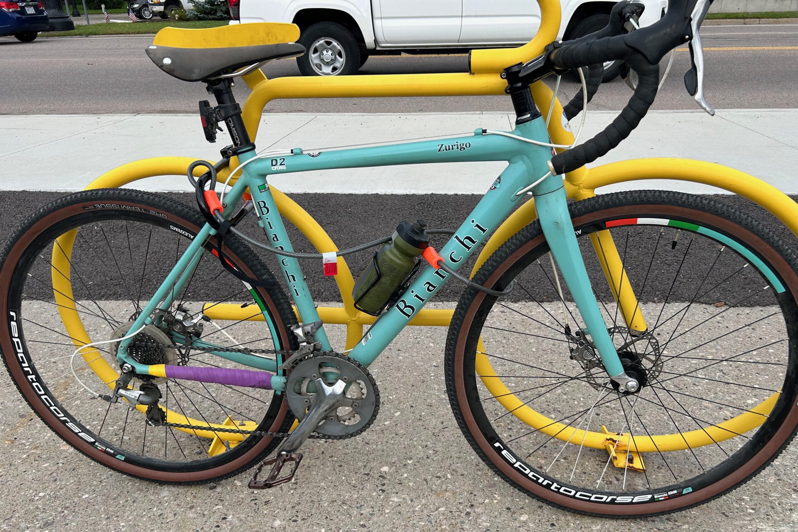 A cable lock in use locking a bike to a bike rack