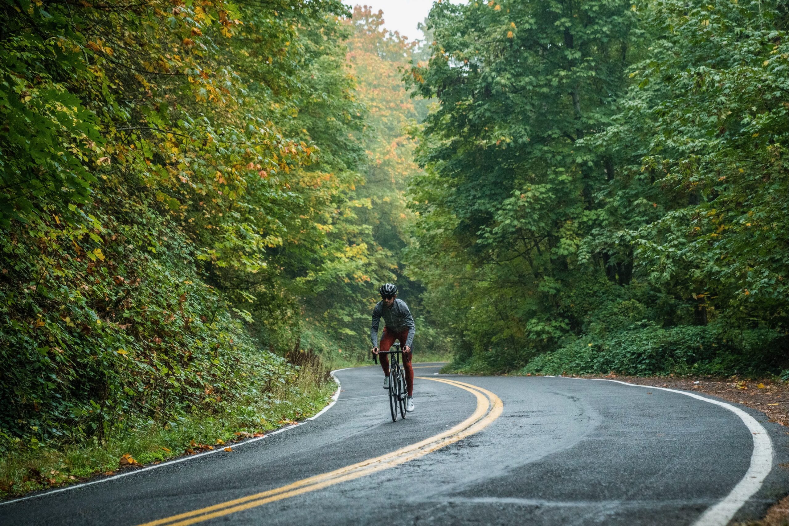 Action shot riding on a wet road in the fall wearing the Ornot Thermal Cargo Bib Tights