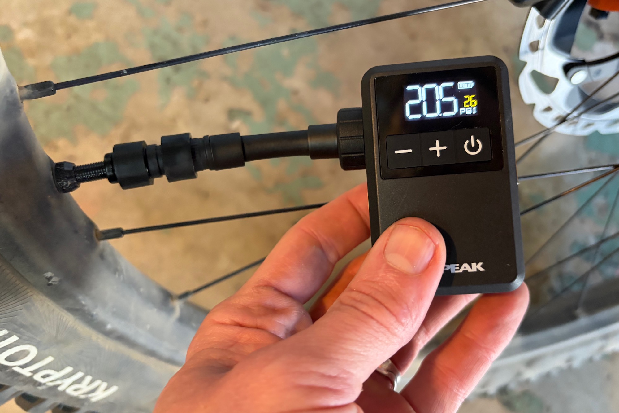 Using the Topeak E-Booster Digital Mini electric inflator to pump a mountain bike tire.