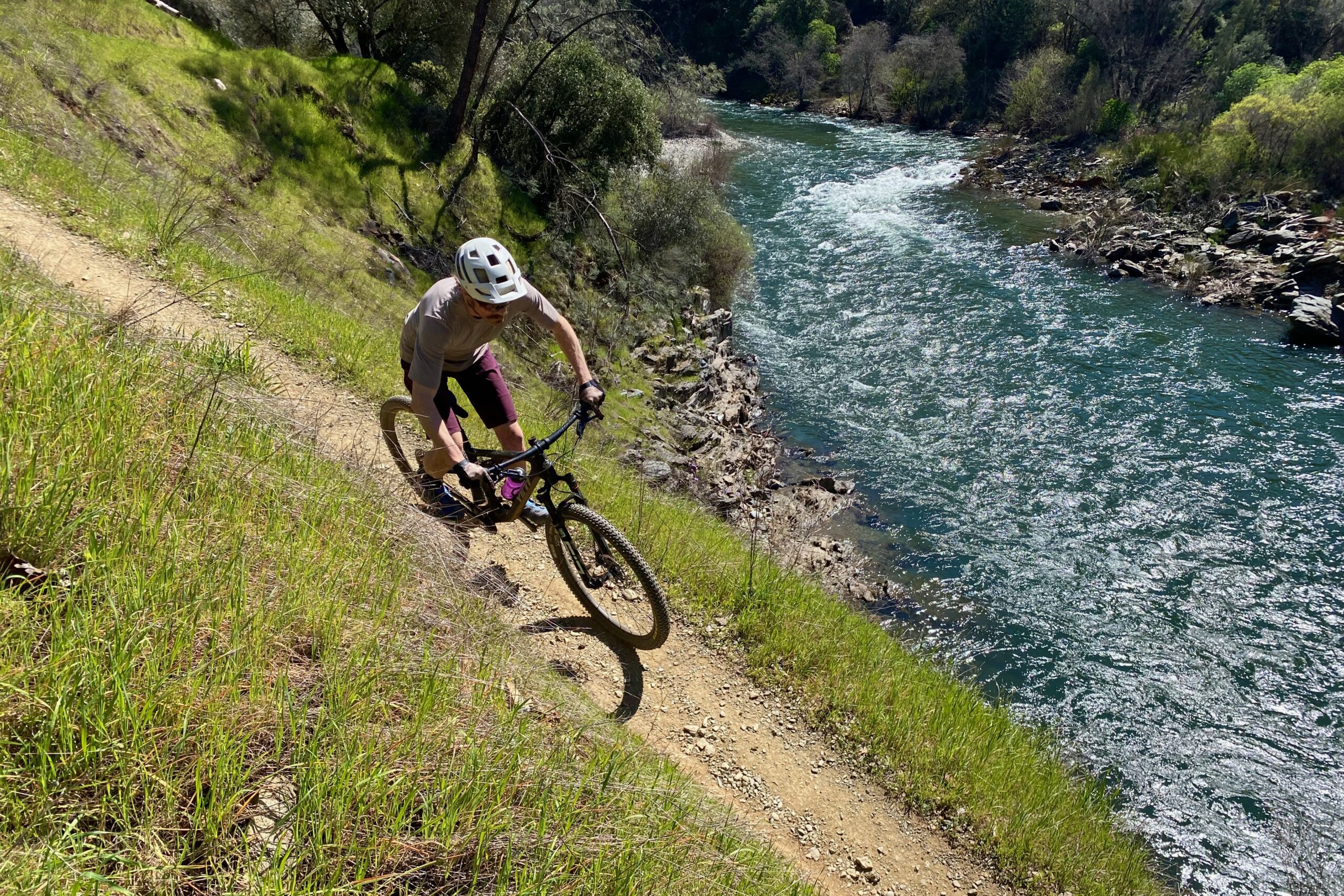 Riding the Yeti ASR on a narrow singletrack trail above a river