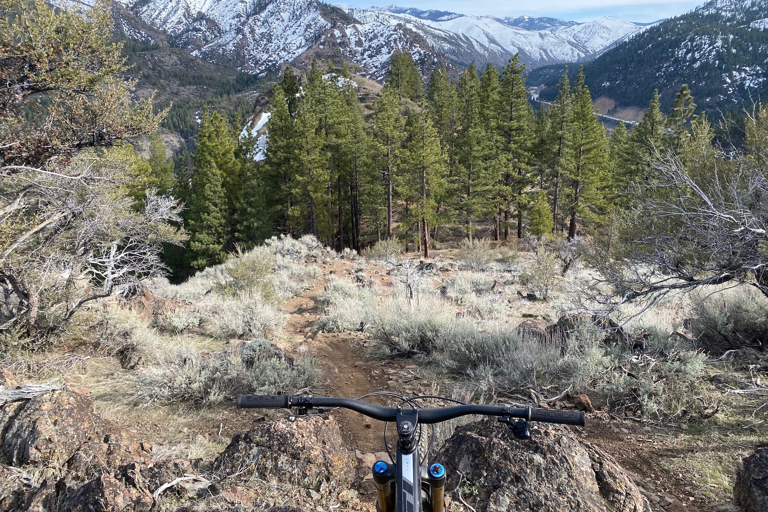 Looking over the handlebar of the SB165 down a steep rock singletrack trail