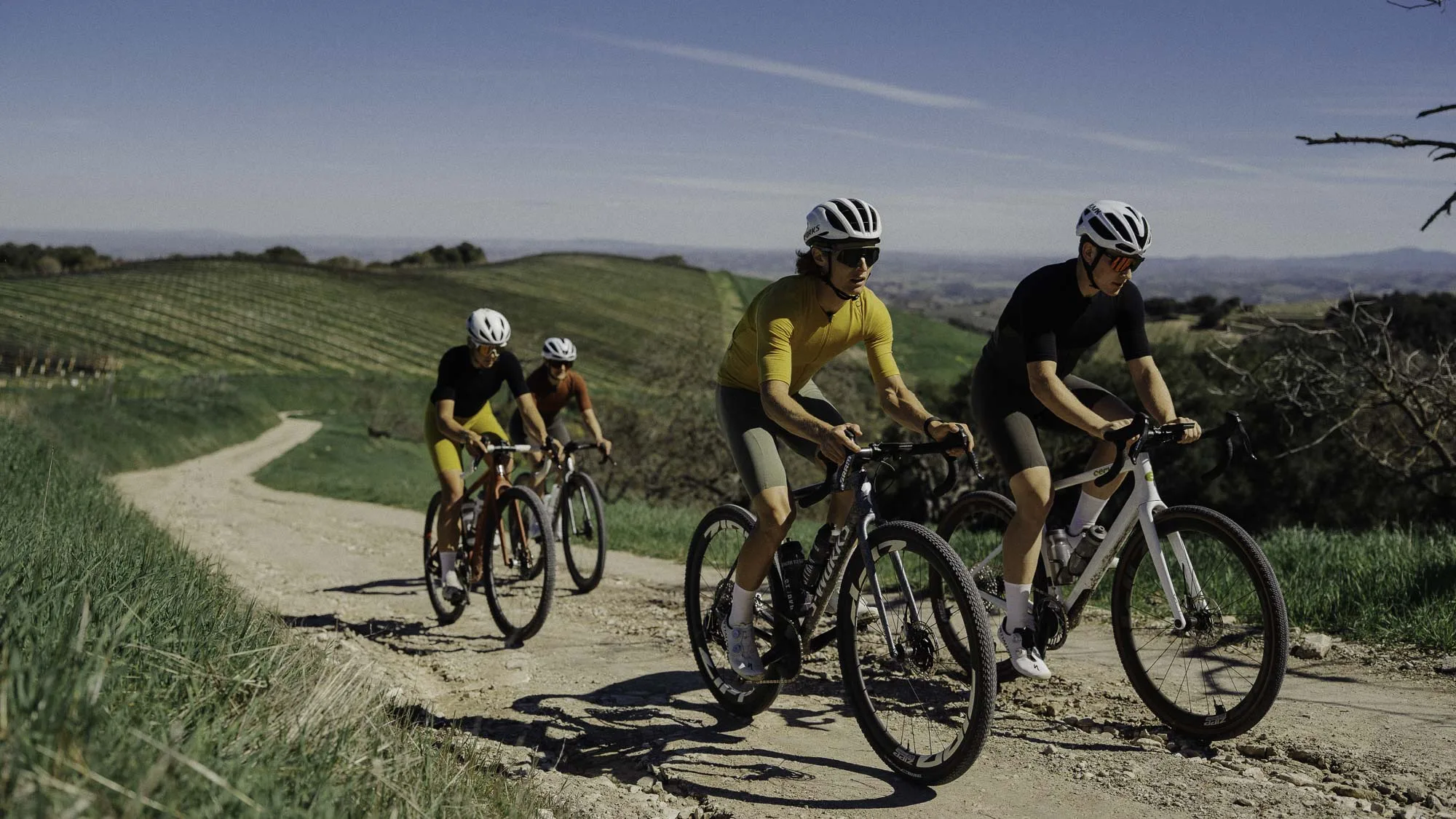 Riders climb on a gravel road wearing Velocio's Luxe range of apparel.