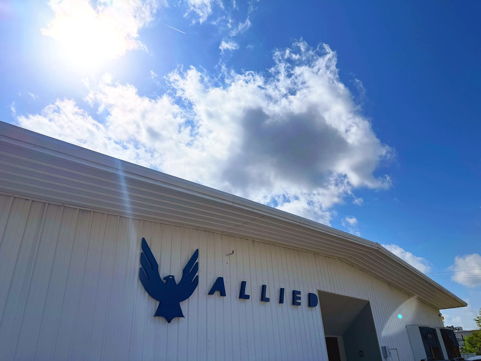 allied cycles headquarters building shown from front with a blue sky behind it.