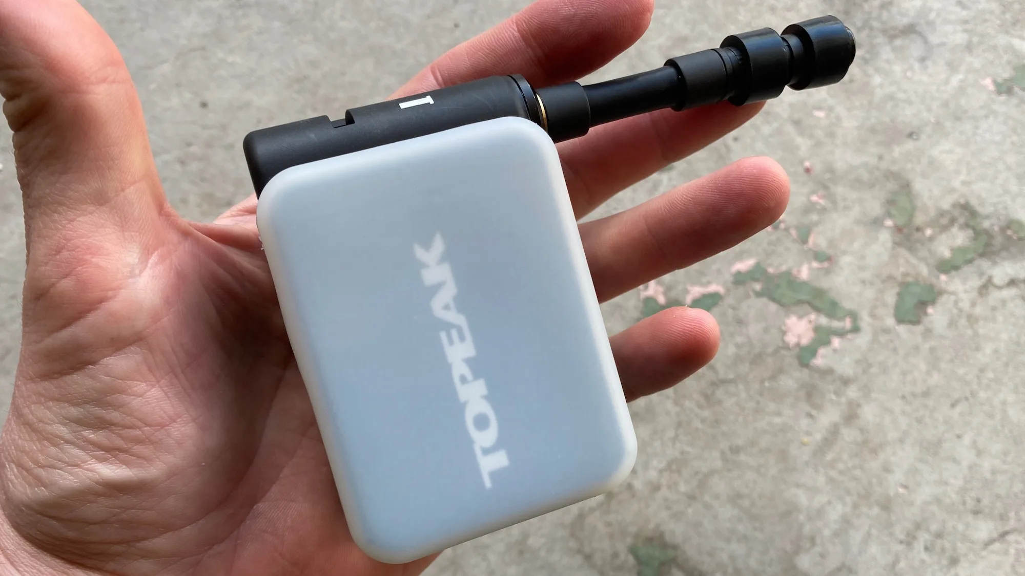 The Topeak e-booster digital electric mini-pump in the palm of a hand