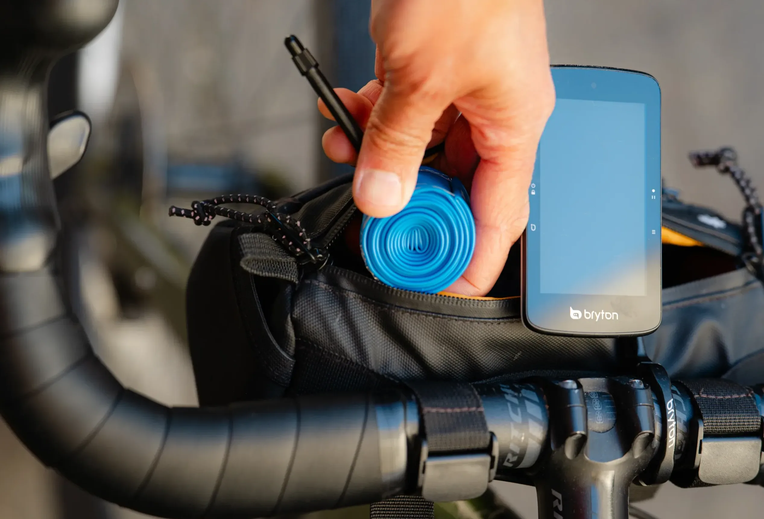A rider inserts a milKit TPU tube into a handlebar bag.