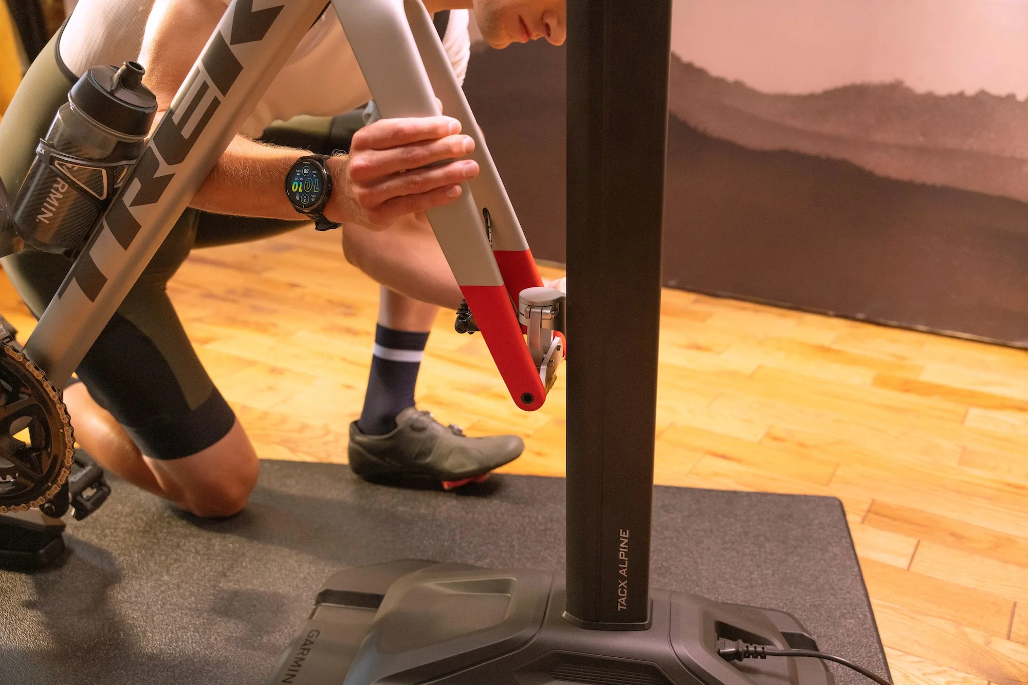 A rider attaching a fork to the dynamic fork mount on the TacX Alpine climbing simulator