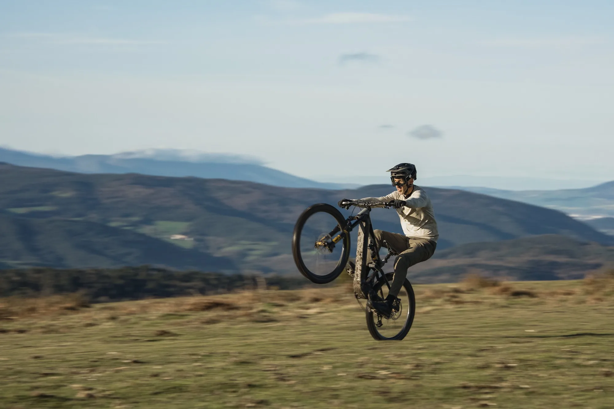 A mountain biker doing a wheelie across a field on a bike using the Mahle m40 drive system