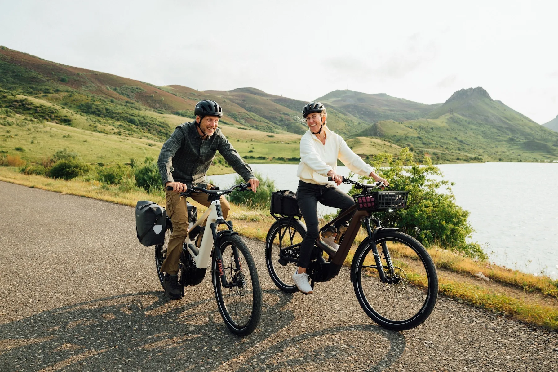 A couple riding Orbea Muga bikes by a picturesque lake