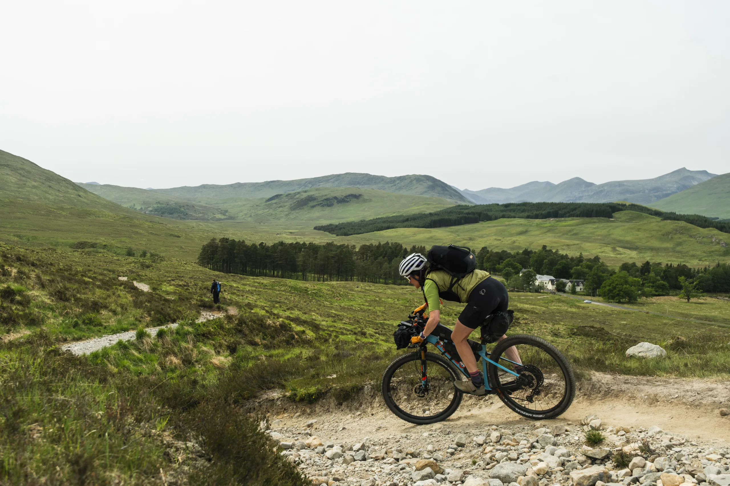a woman is wearing a Restrap Rolltop Hydration Vest while bikepacking