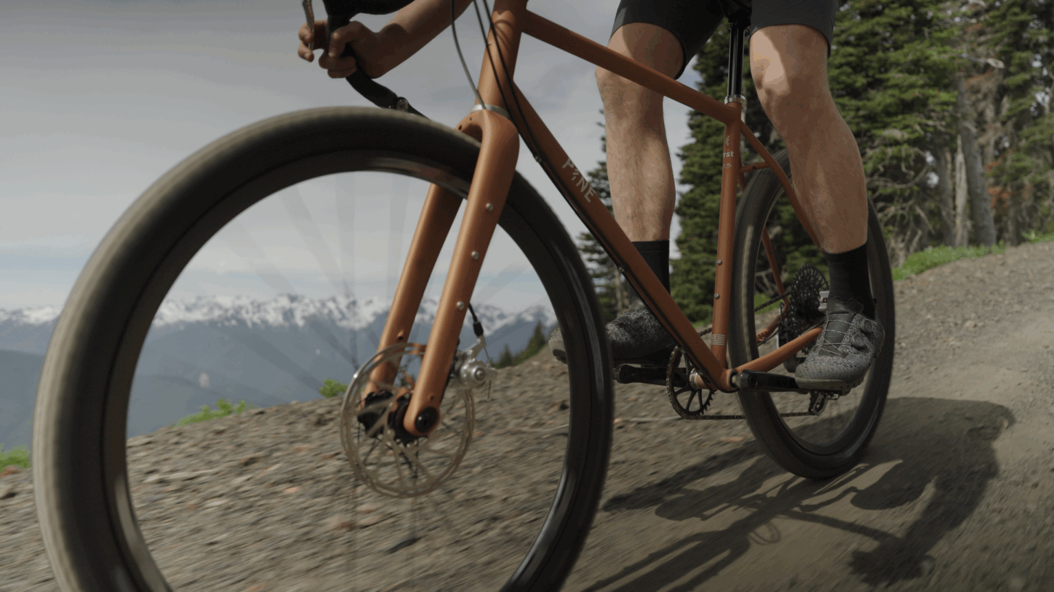 a photo of a person riding the Pine Cycles FRST on a gravel road
