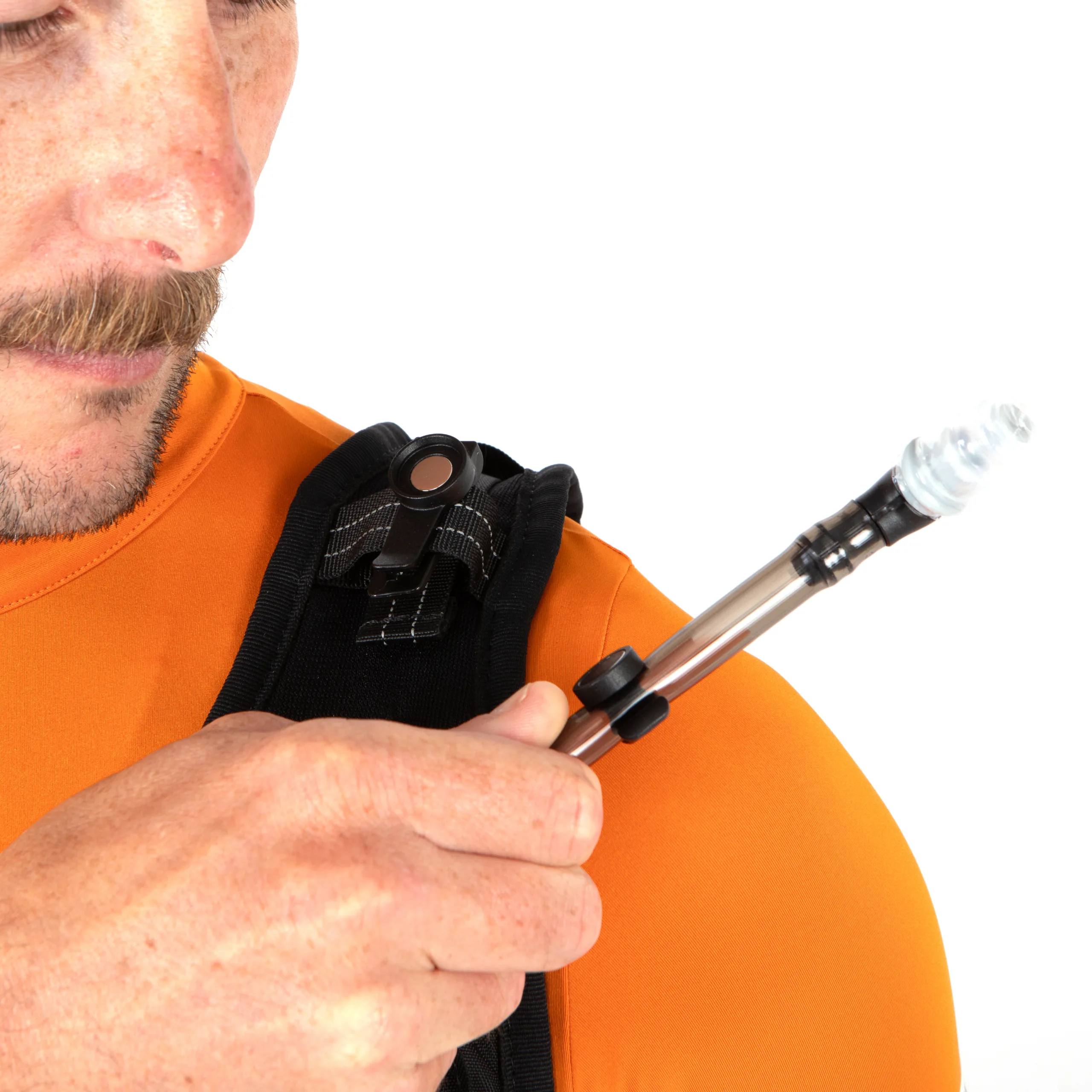 The man is using the magnetic clip on the Restrap Rolltop Hydration Vest to secure the bladder's nozzle to the shoulder strap