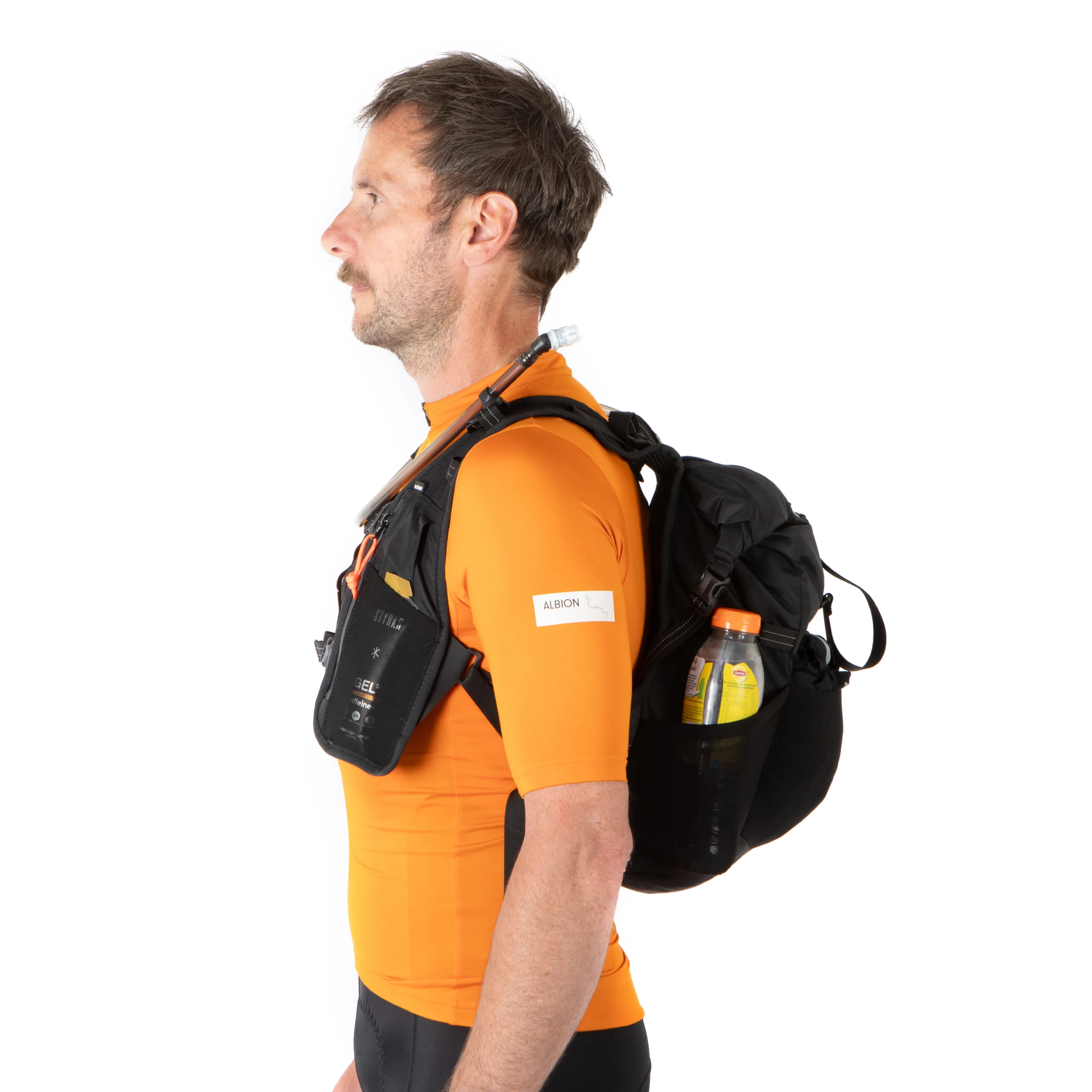 A man in an orange jersey wearing a Restrap Rolltop Hydration Vest from left profile