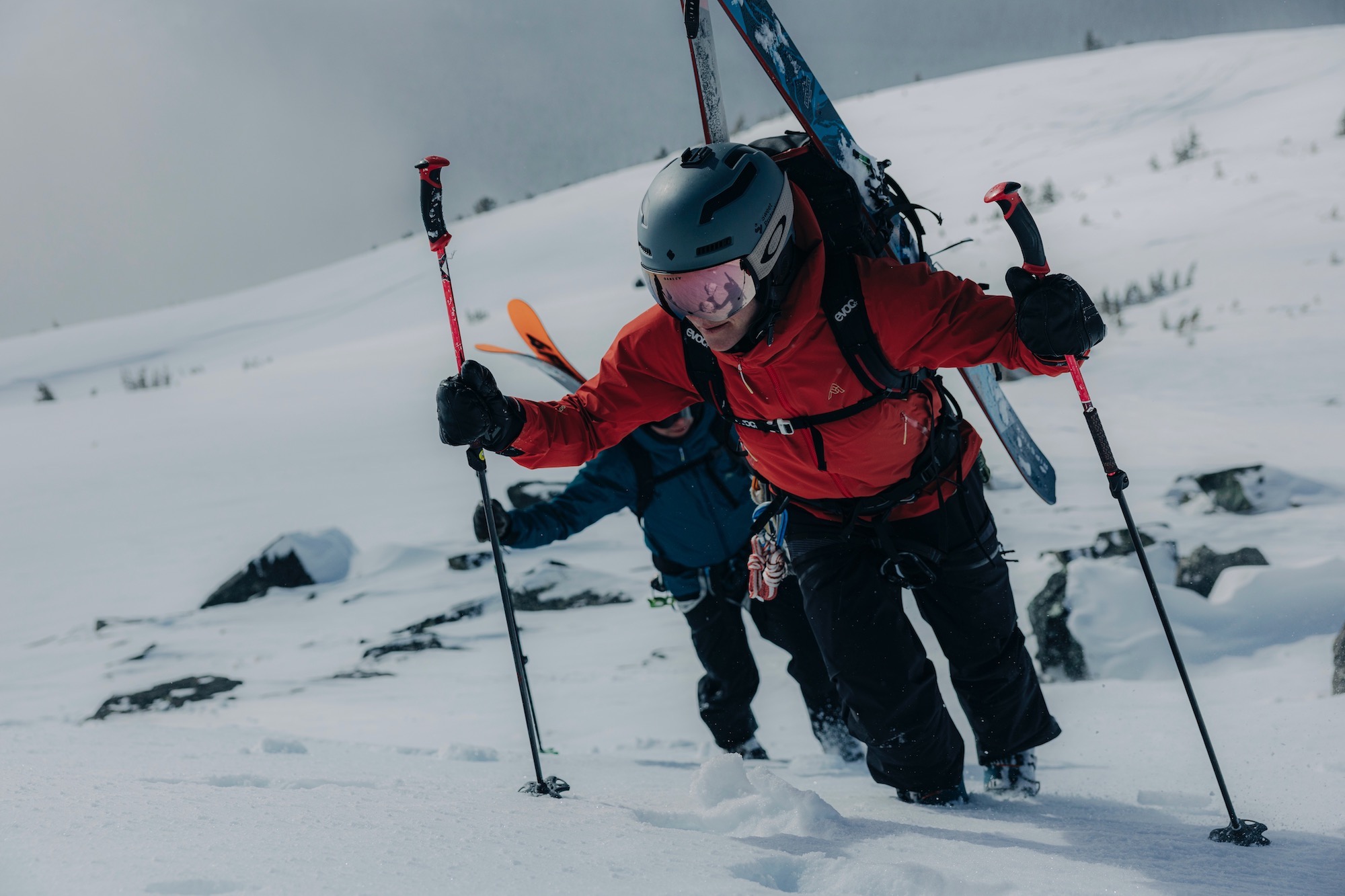 Two backcountry skiers climbing a mountain while wearing the 7Mesh Guardian jackets.