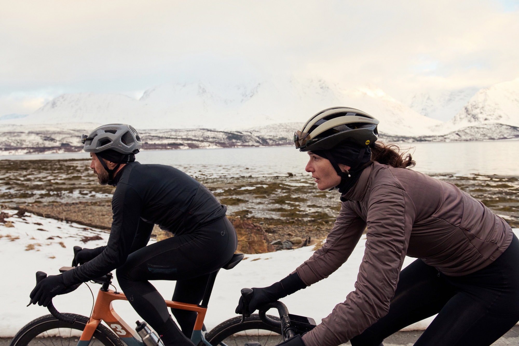 A male and female riding in the new Velocio Alpha Air jacket in cold conditions