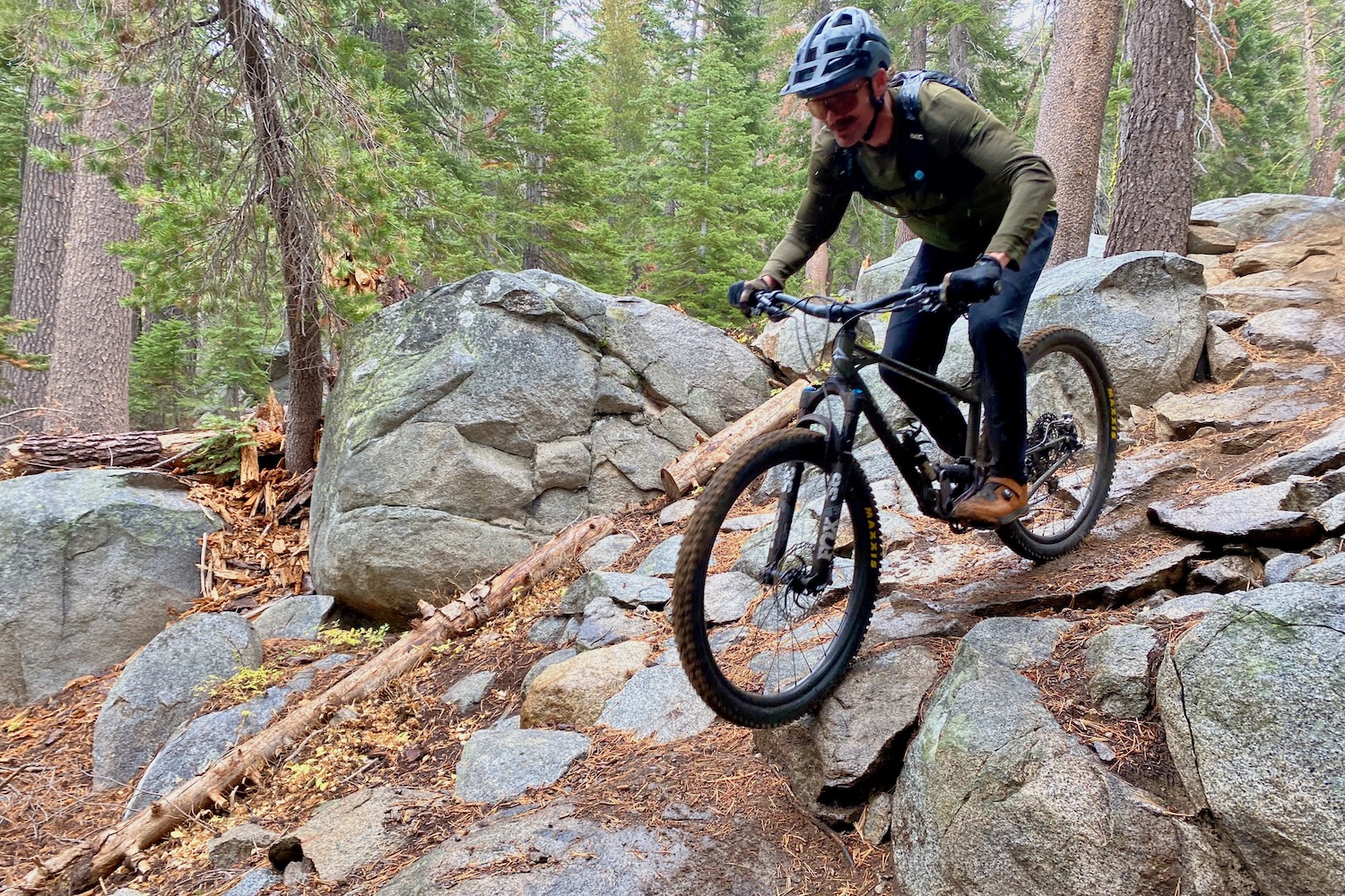 riding down a steep rocky section of trail on the Apogee One
