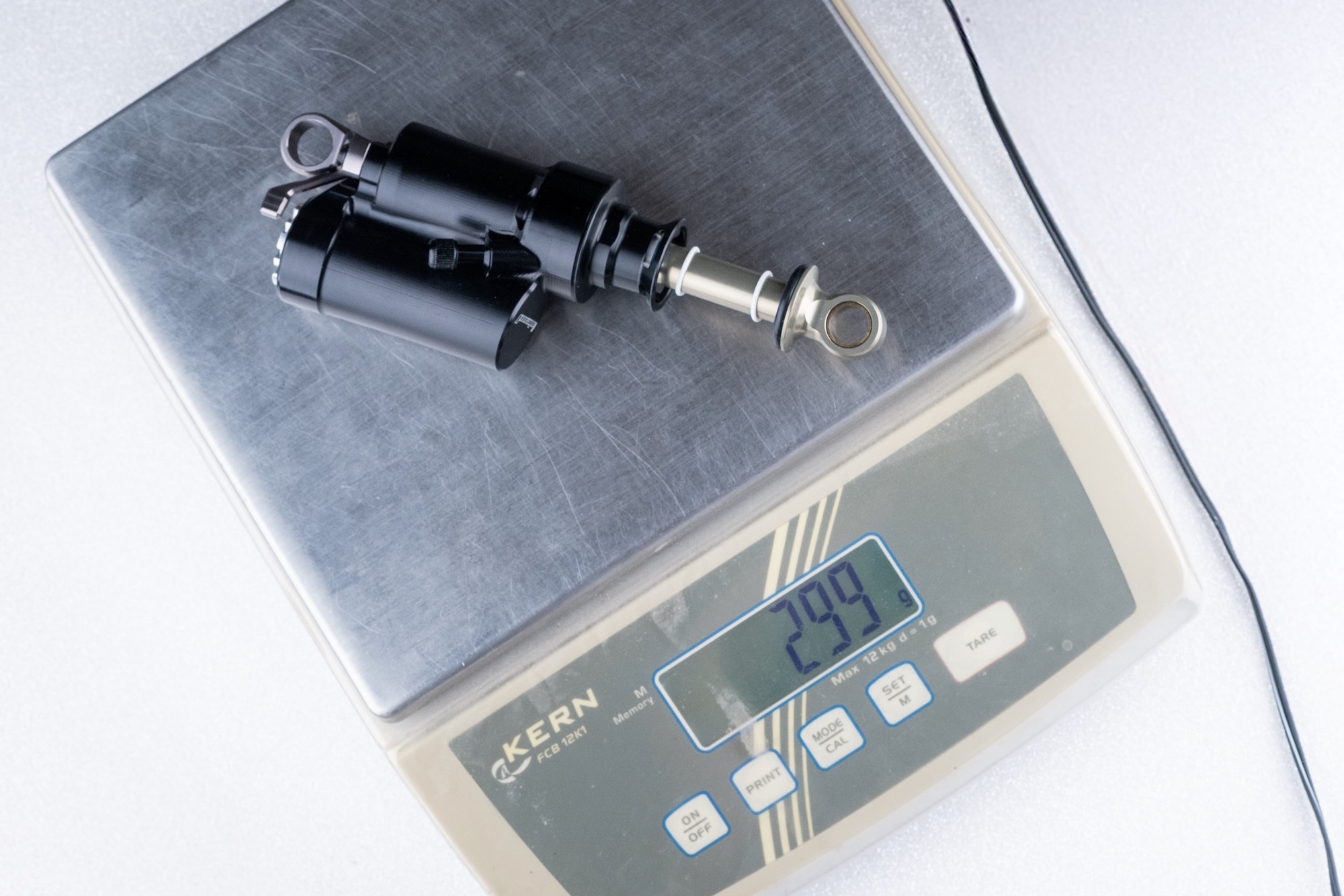 the 45 mm stroke Hover Monocoque Light on a scale showing the 299 gram weight.
