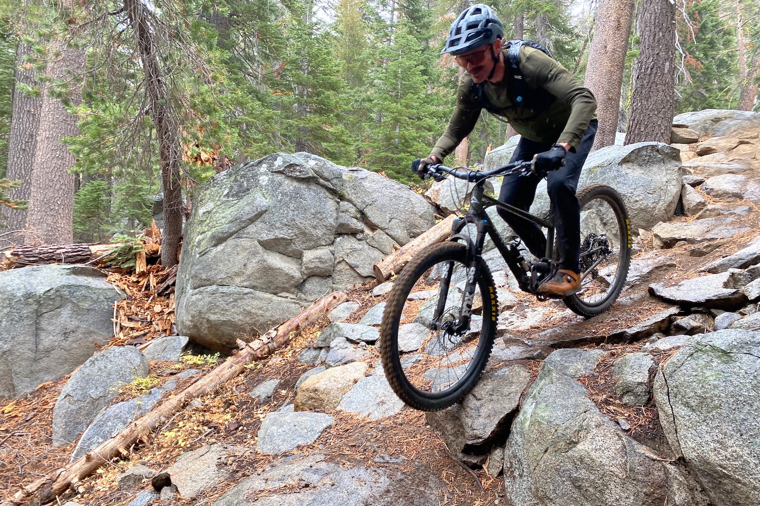 Riding in the Velocio Ultralight Trail Pants down a rocky feature on a mountain bike