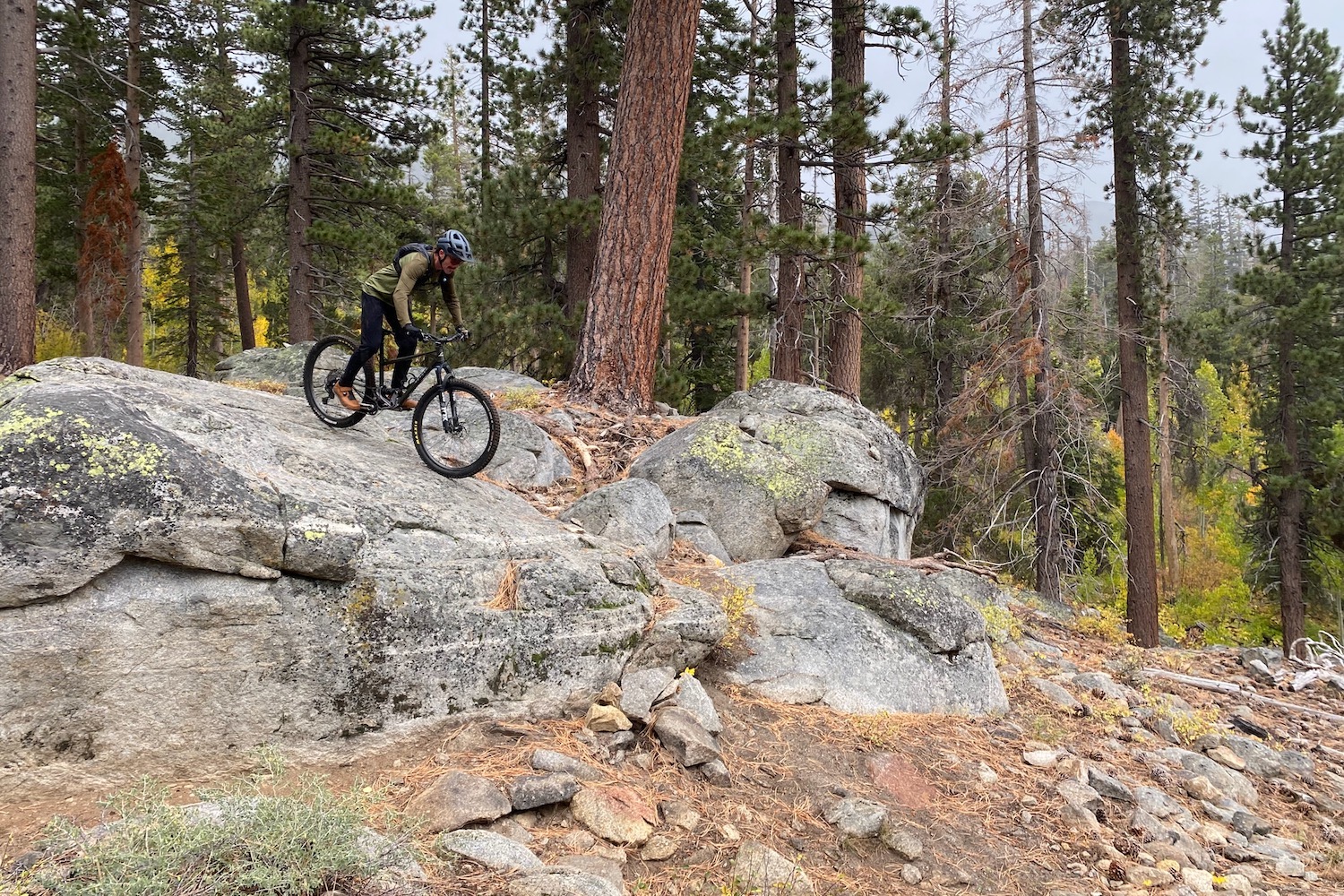 riding over a huge granite boulder wearing the Ultralight TRAIL pants.