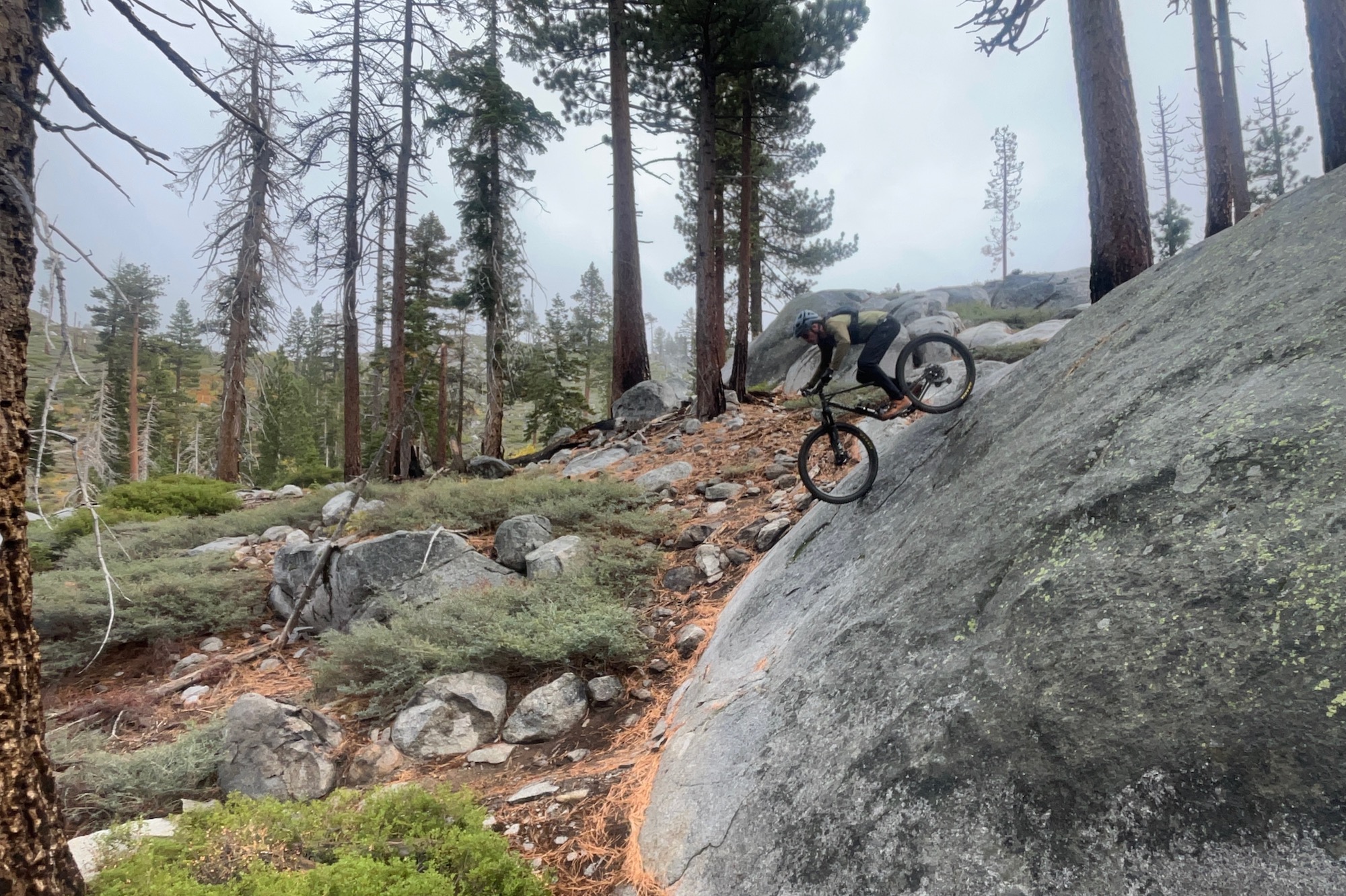 riding down a wet rock slab while wearing the velocio Ultralight Pants