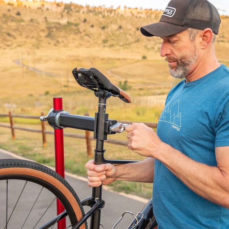 a man loading a bike into the Pro Ultralight stand and tightening the clamp jaws with the spinner knob