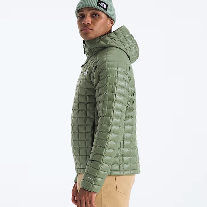 studio image of a man wearing the North Face Thermoball Hooded Jacket viewed from the side