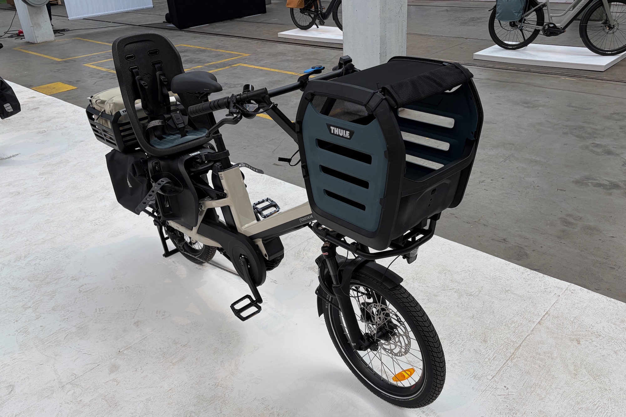 a cargo bike with the pet carrier mounted on the front cargo rack.