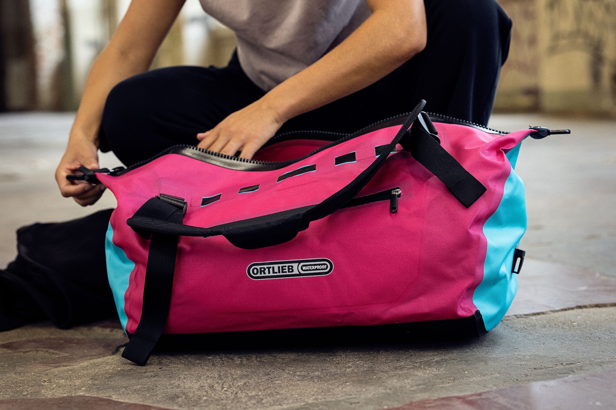 A person loading the Ortlieb Duffle Lite bag