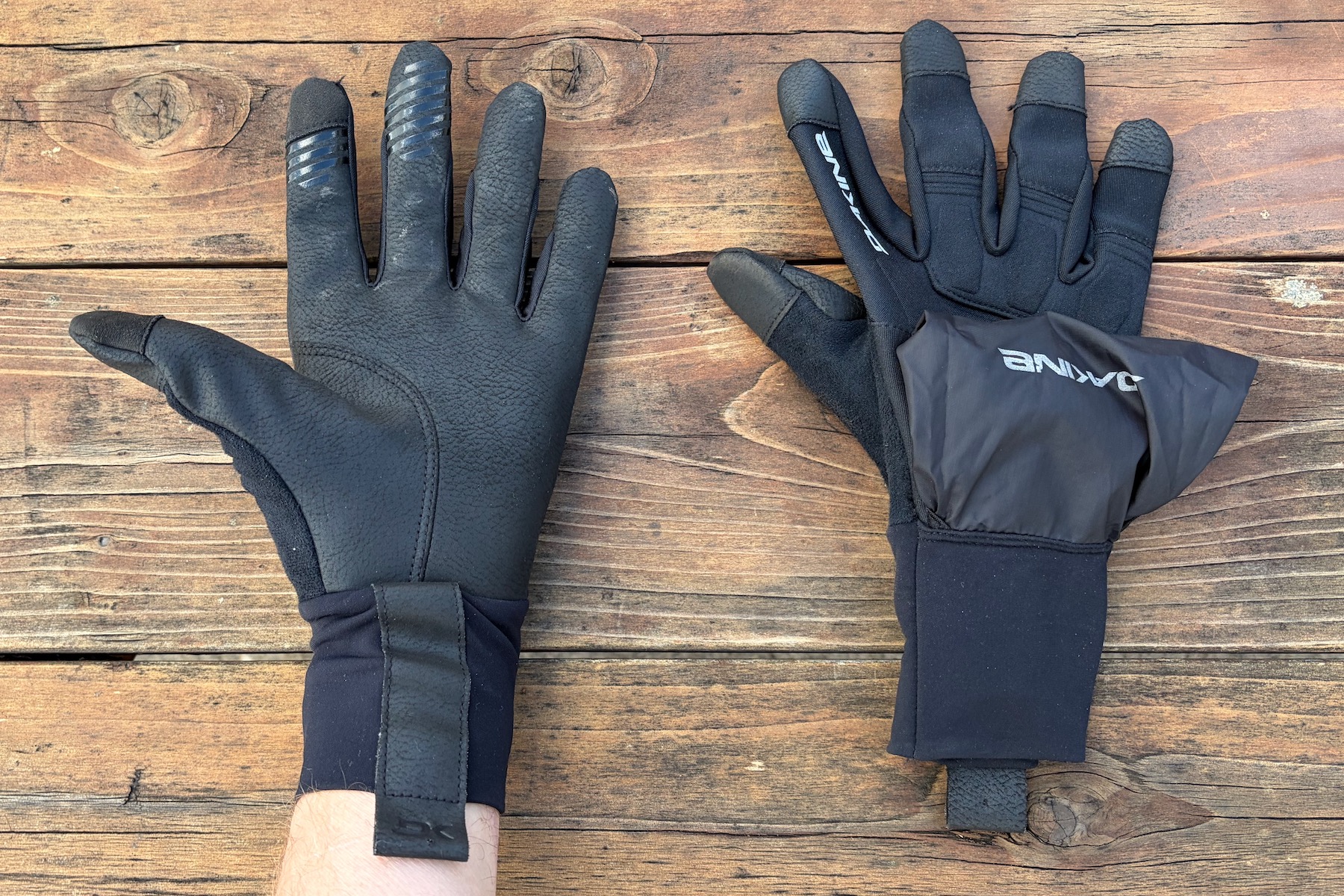 wearing the White knuckle glove on one hand with the palm up, and the other glove on a table showing the rain cover