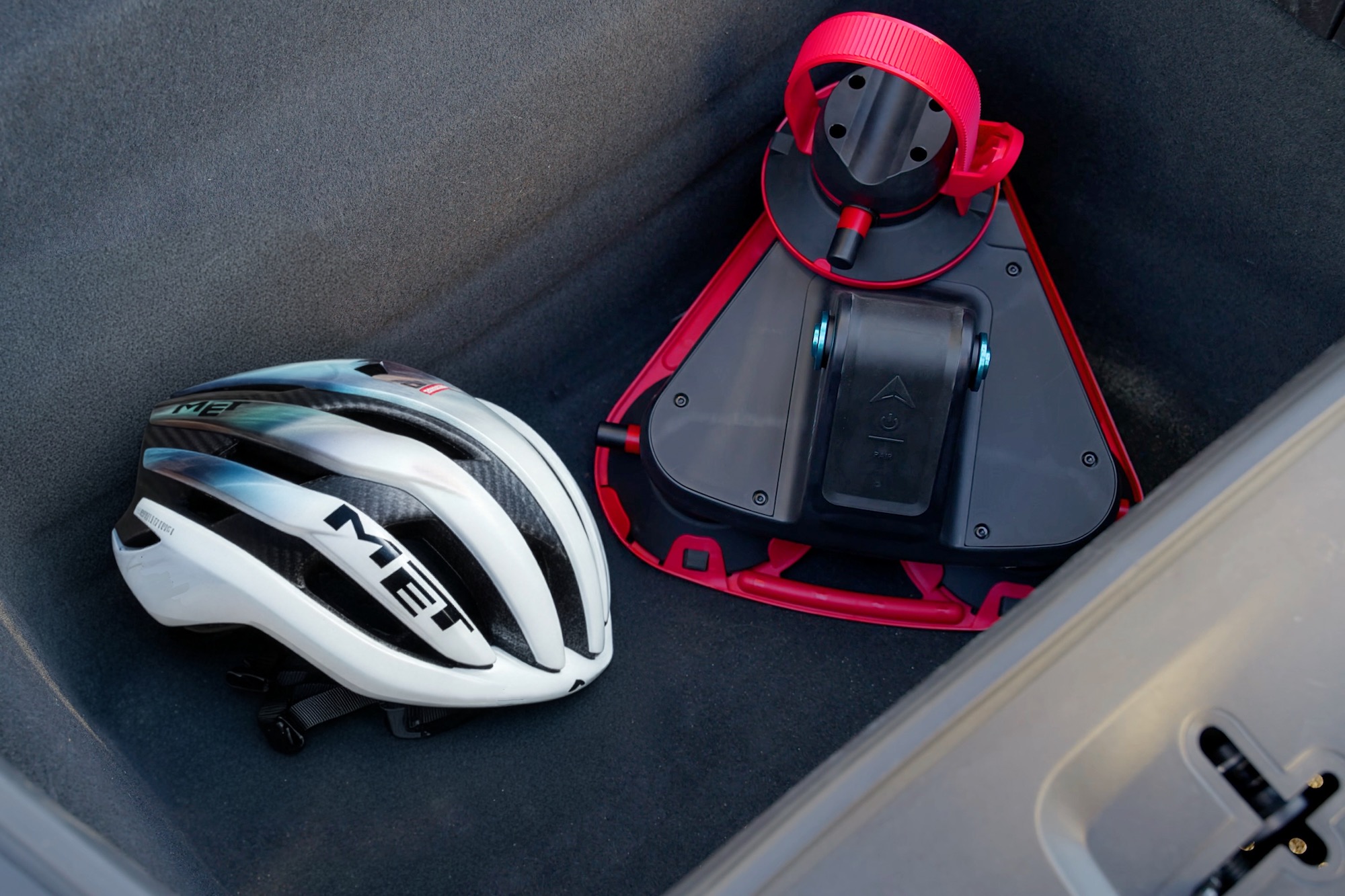 the Smart Suction Go rack packed in the back of a car with a bike helmet (for size comparison) while not in use.