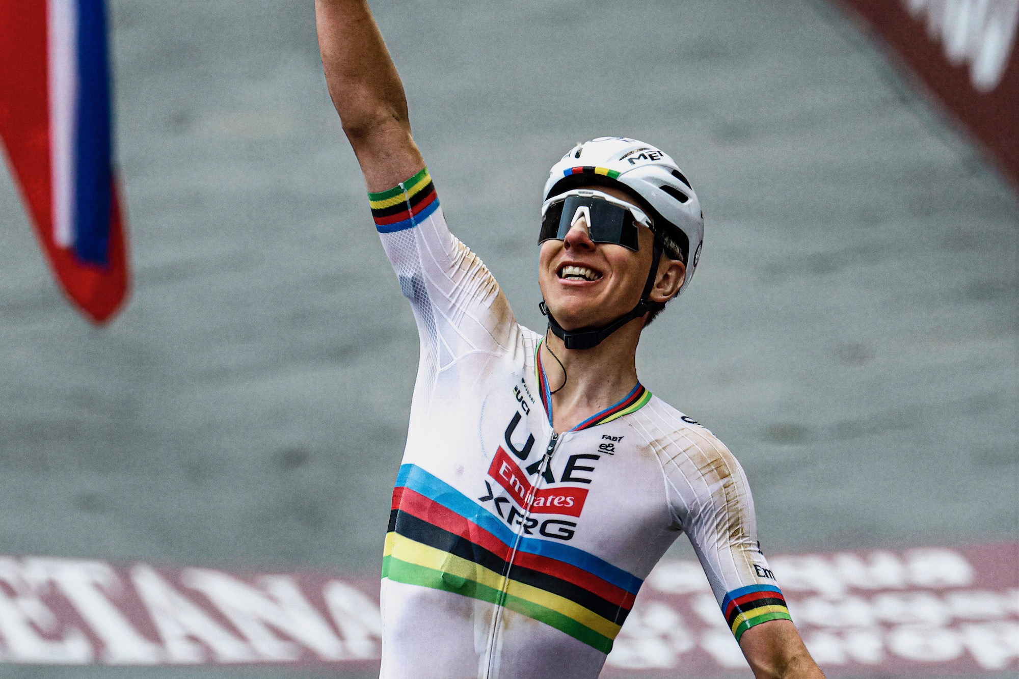 Tadej Pogacar raising his arm after wining the Strade Bianche last weekend