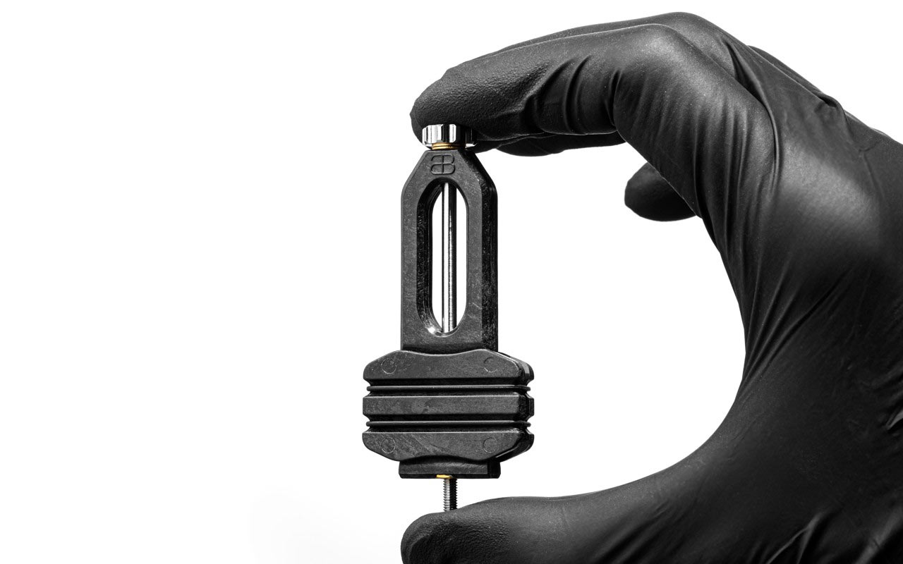 absoluteBLACk four-piston mountain bike brake press tool held by a gloved hand.
