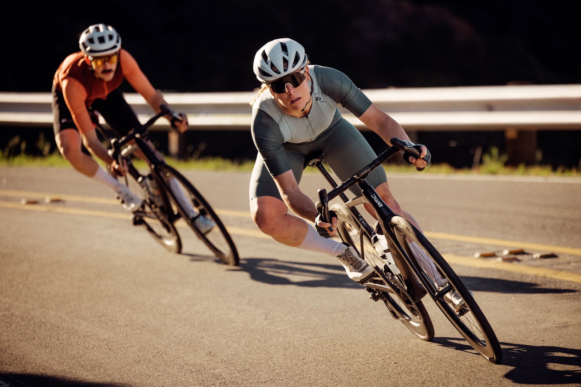 female and male riders on road bike riding in the new Pi PRO/BLACK apparel