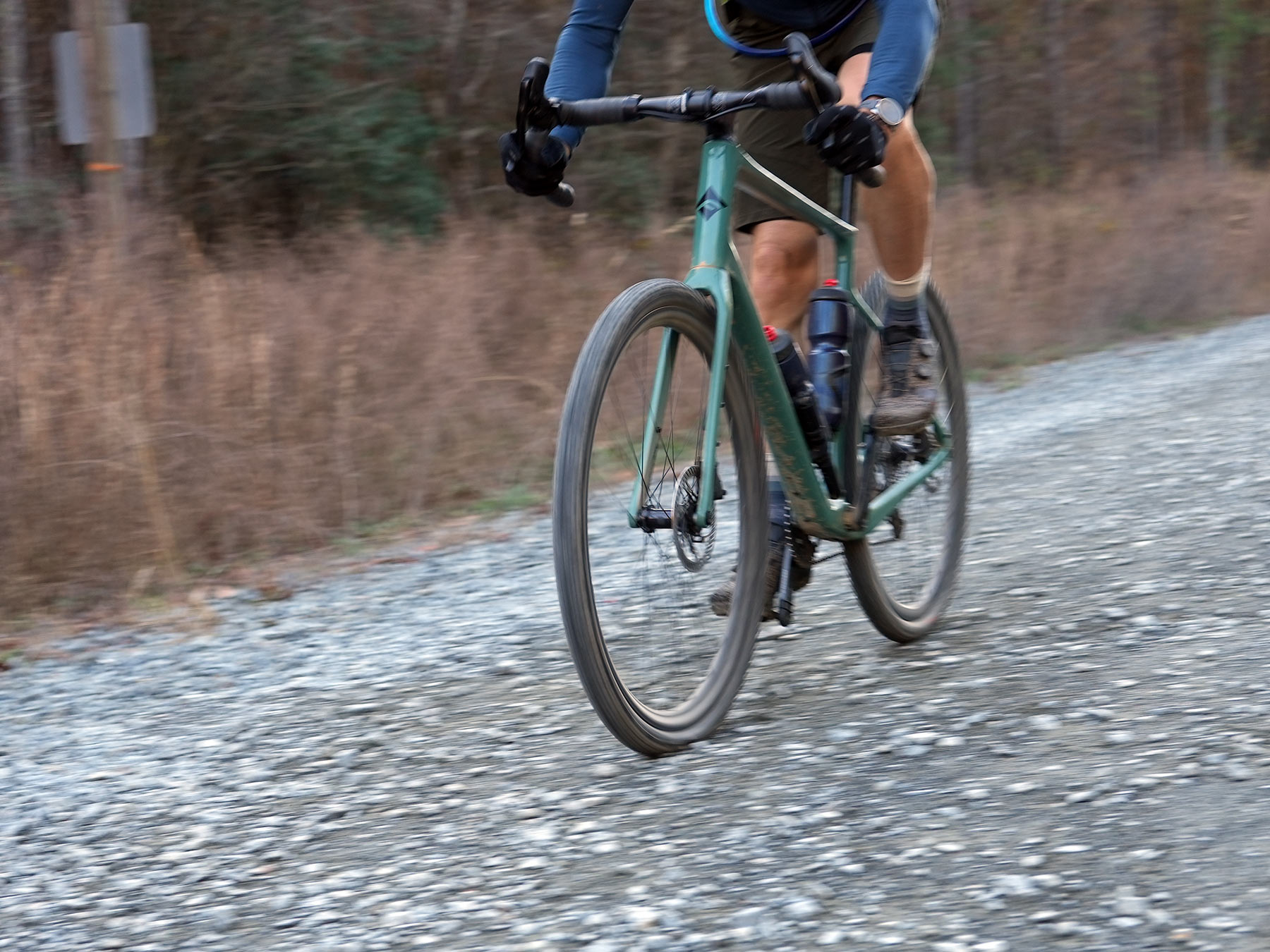cyclist riding bike with fulcrum rapid red carbon gravel wheels.