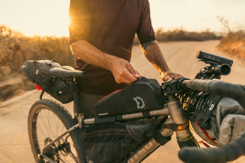 a rider with the extended paly top tube bag mounted on a bikepacking bike.