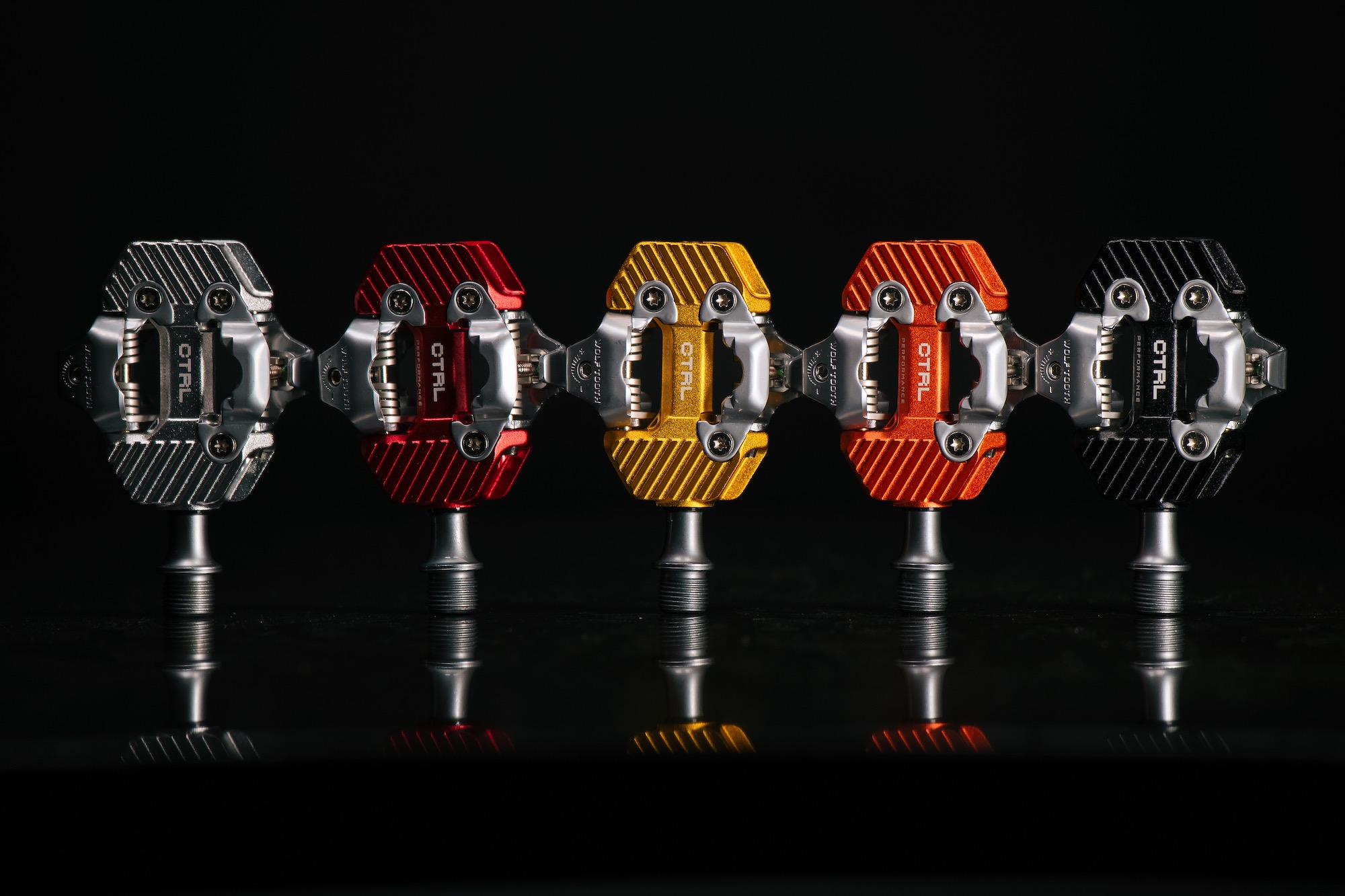 studio image of the Wolf Tooth CTRL Performance pedals in five different colors.