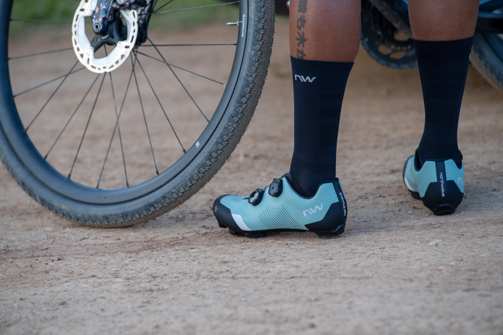 a person standing on a gravel road while wearing the Northwave Striker shoes.