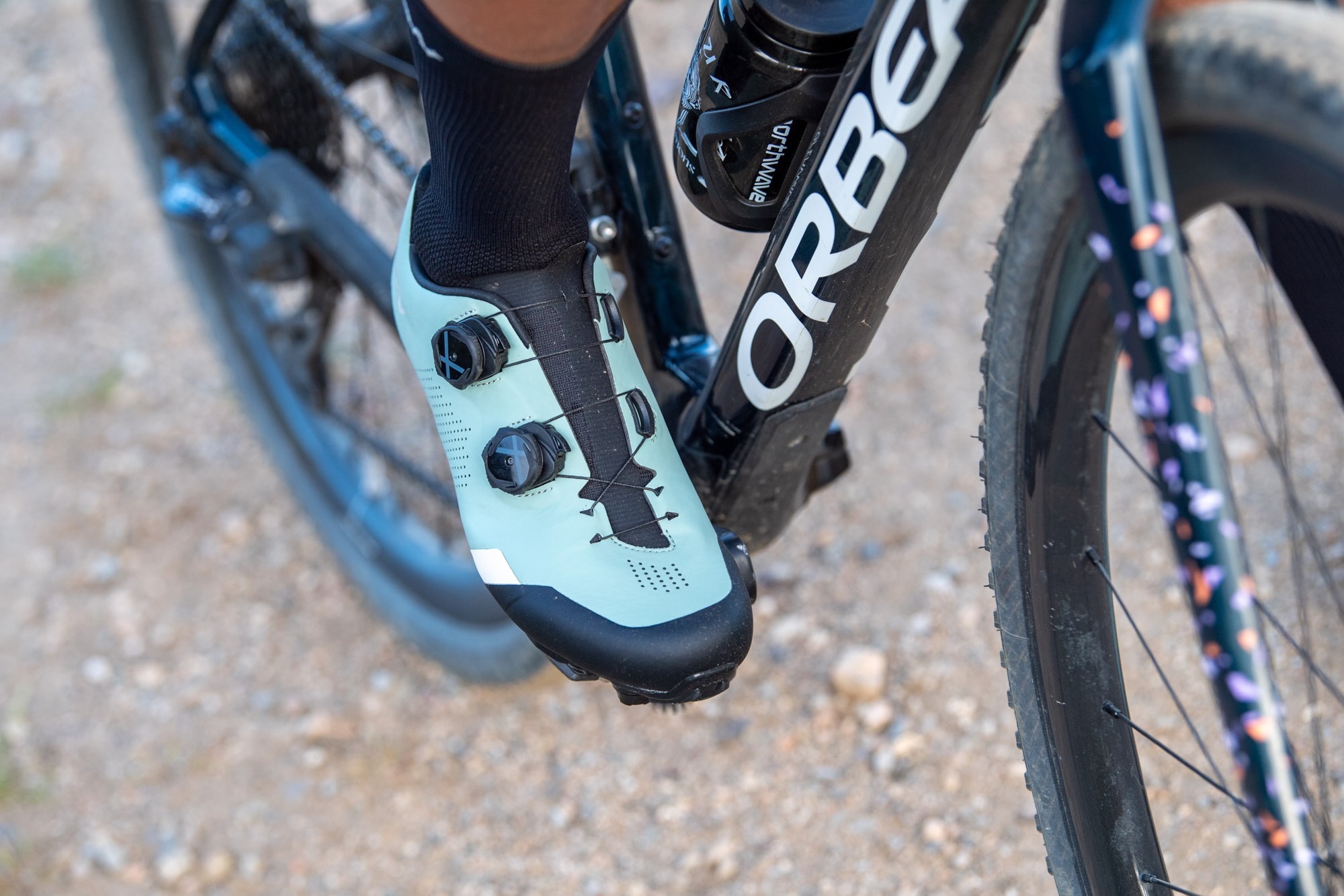 a person wearing the Northwave Striker pedaling a gravel bike