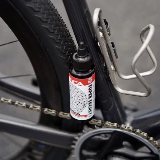 image of the silca Super Secret 2.0 bottle sitting on a chain on a bike.